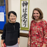 Japanese-caligraphy-teacher,-Mrs.-Fukuhara,-poses-in-front-of-one-of-her-student's-kakejiku-scrolls-with-Sister-Nettie-Francis..jpg
